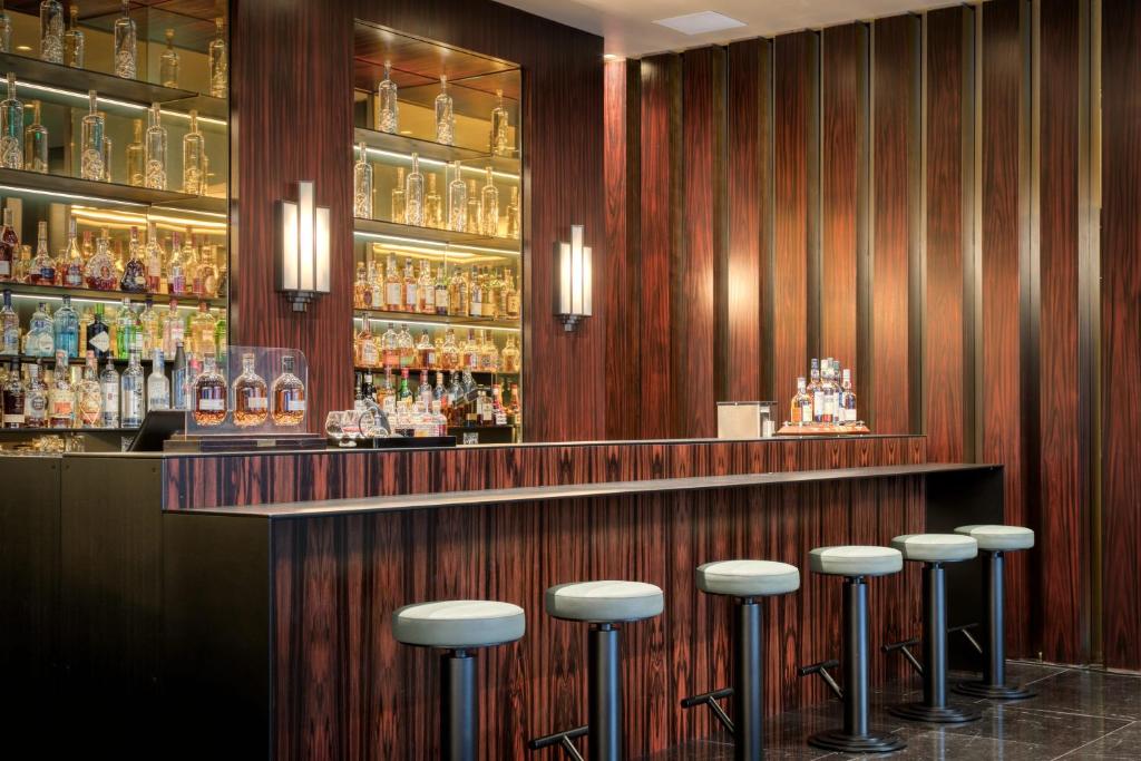 un bar con una fila di sgabelli in una stanza di Divani Caravel ad Atene