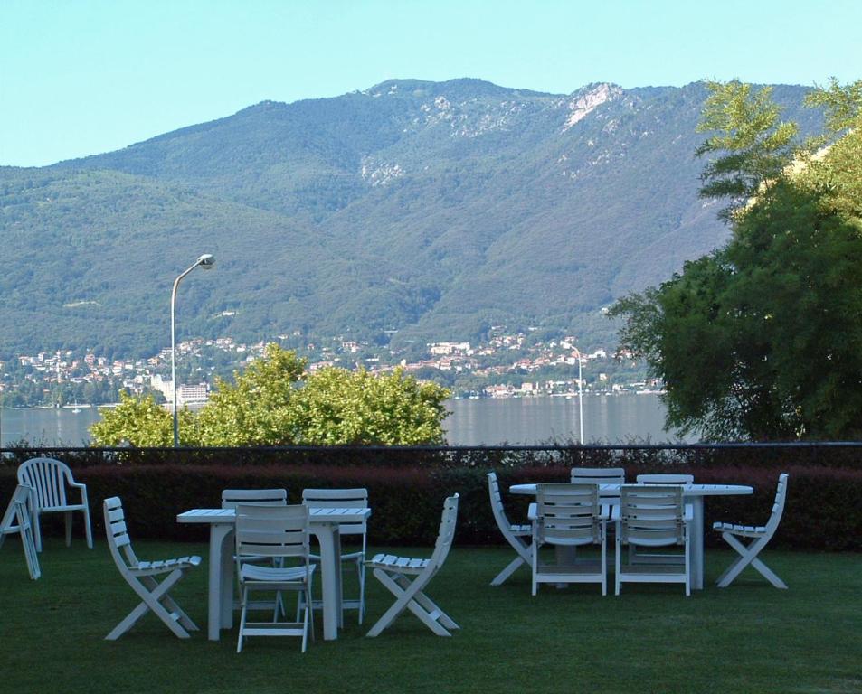 a group of tables and chairs with mountains in the background at Tre ponti monolocale in Verbania