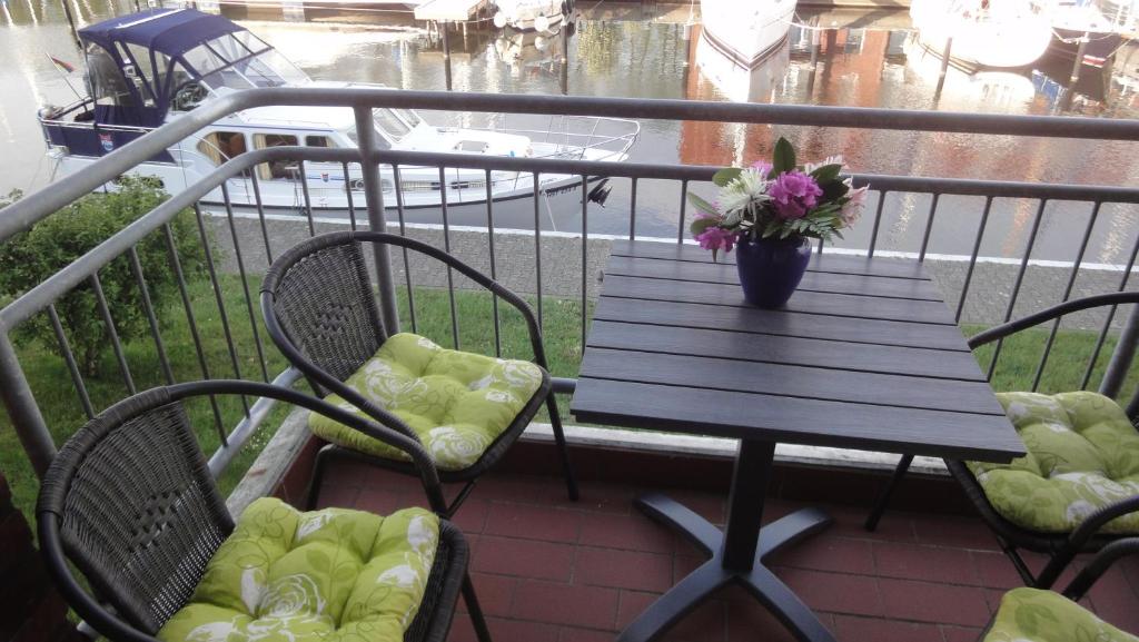 y balcón con mesa y sillas de madera. en FEWO "Hafenblick", en Ueckermünde