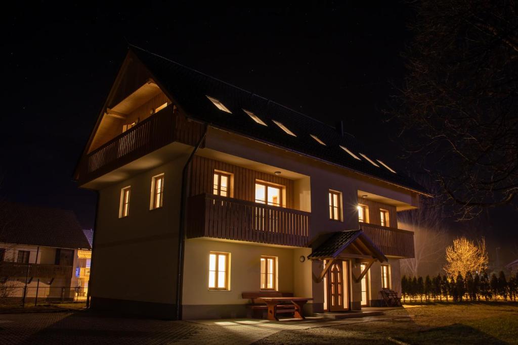 a large house at night with its lights on at Apartments & Rooms Pr' Skalovc in Bohinj