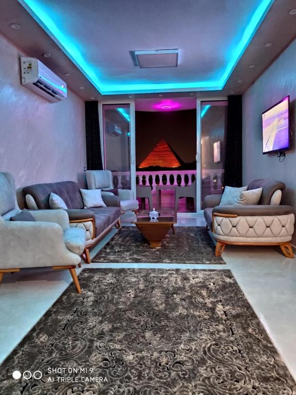 Una sala de estar con sofás y un televisor. en Hi Pyramids, en El Cairo