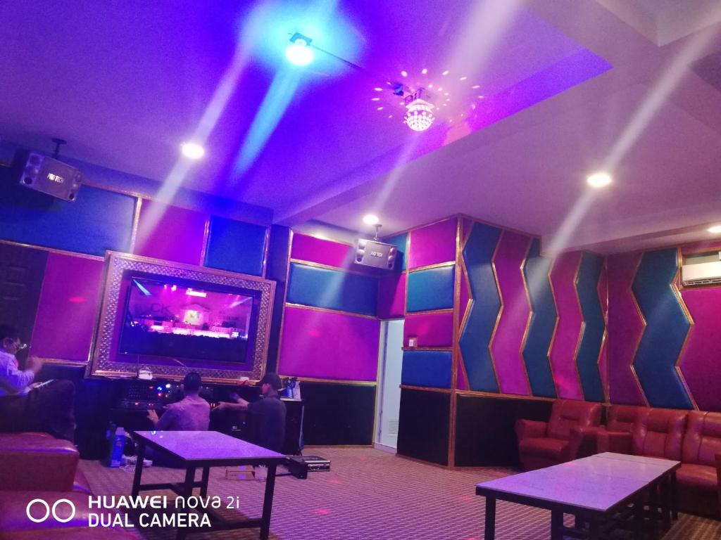 una camera con luci viola e TV a parete di Supreme Hotel Yangon a Yangon