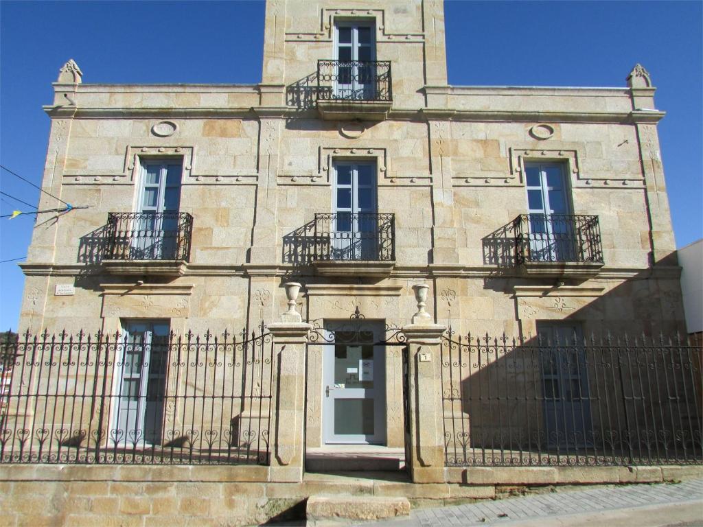 a stone building with balconies and a fence at Posada Real El Brasilero in Saucelle