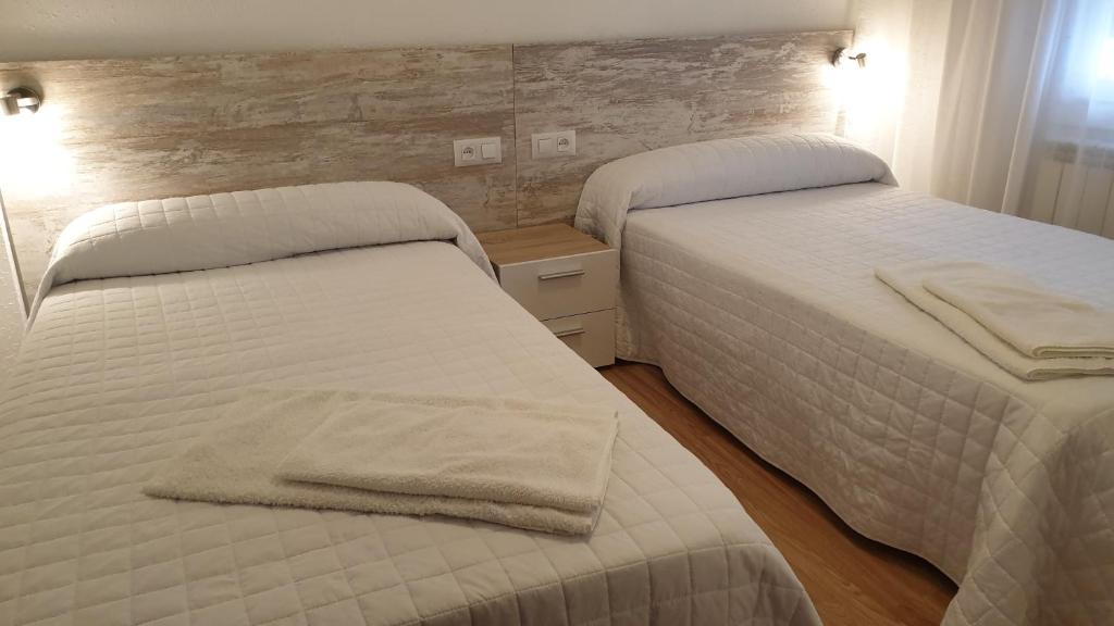 two beds in a hotel room with towels on them at Apartamento La Ruta Del Vino in Haro