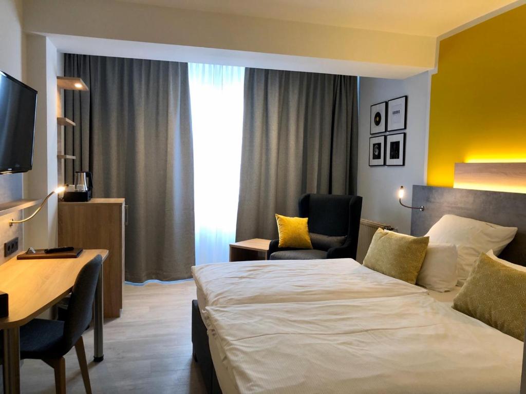 ein Hotelzimmer mit einem großen Bett und einem Schreibtisch in der Unterkunft Hotel Sonderfeld in Grevenbroich