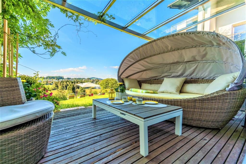 eine Terrasse mit einem Korbstuhl und einem Tisch in der Unterkunft Haus am Weinberg II in Seekirchen am Wallersee