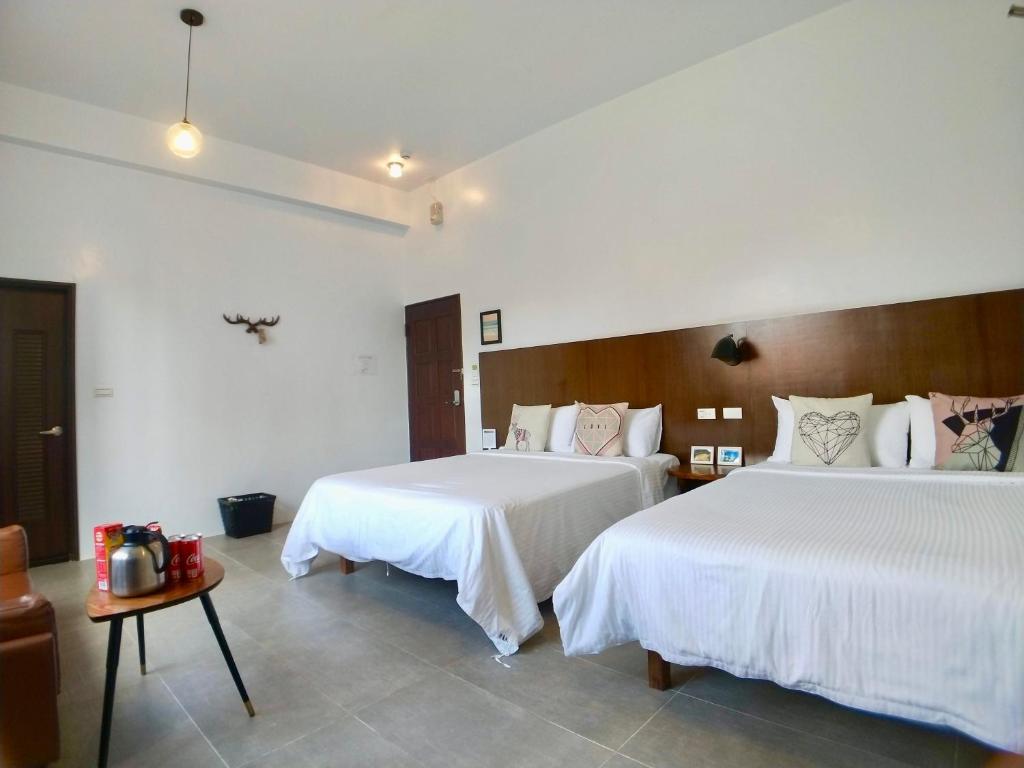 Habitación de hotel con 2 camas y mesa en Love Summer B&B, en Eluan