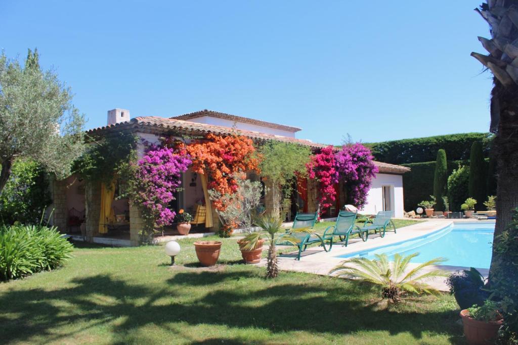 a house with flowers and a swimming pool at La Villa Topi in Antibes