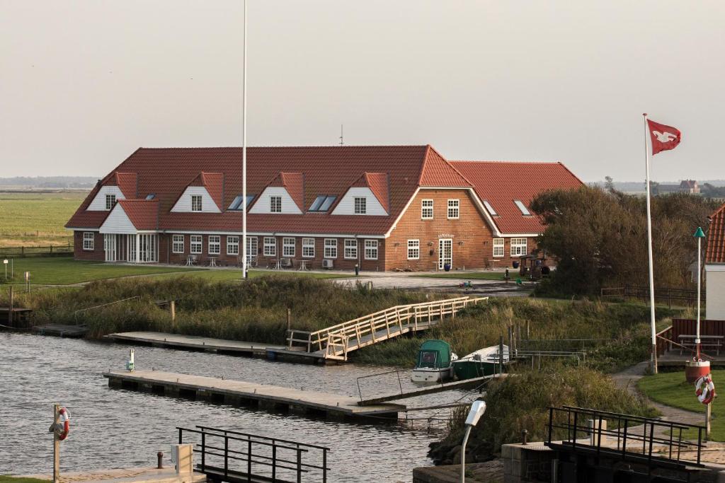 um grande edifício com uma doca ao lado de uma massa de água em Kammerslusen em Ribe