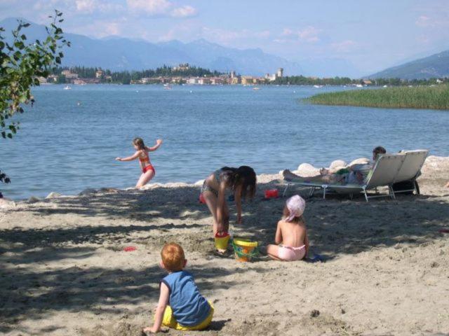 a group of people playing on the beach at Bungalow COMFORT in Sirmione