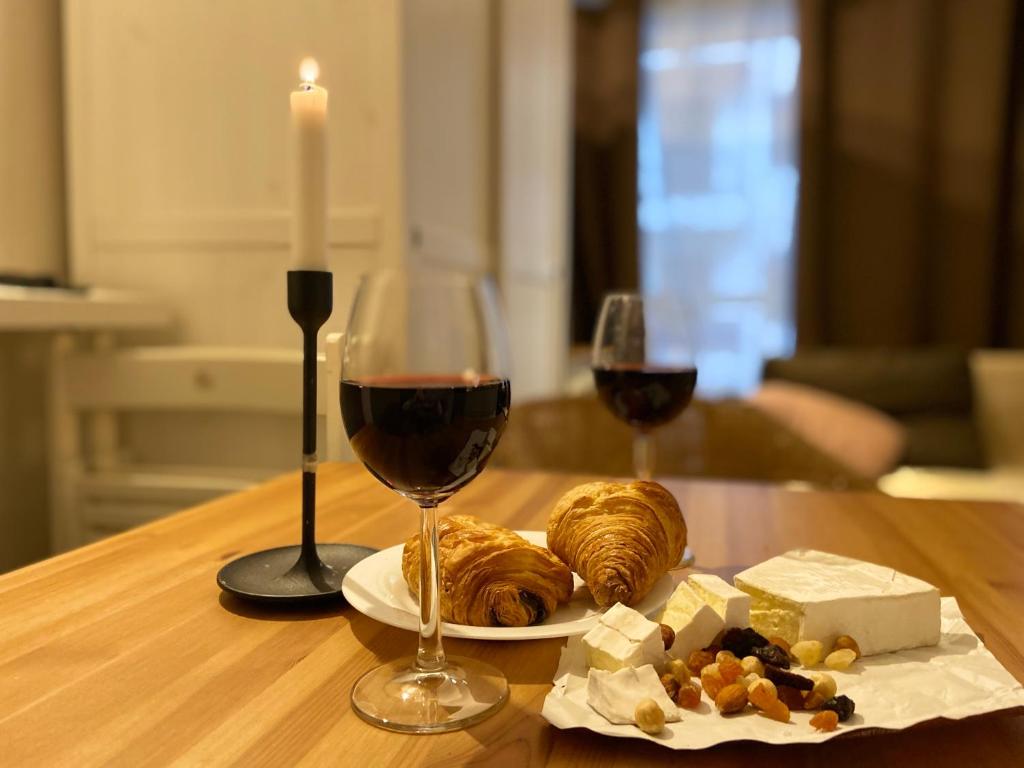 une table avec une assiette de nourriture et deux verres de vin dans l'établissement Super studio in the heart of Nice!, à Nice