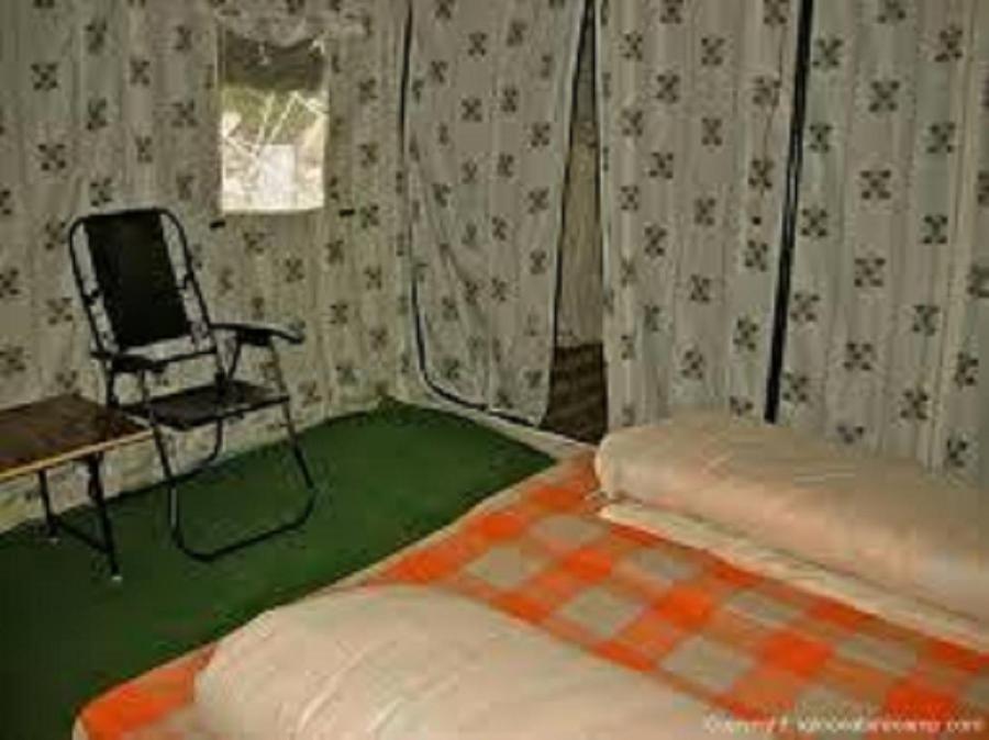 Una habitación con una cama y una silla en una tienda de campaña en Jispa Journey Camp Lahoul & Spiti, en Manali