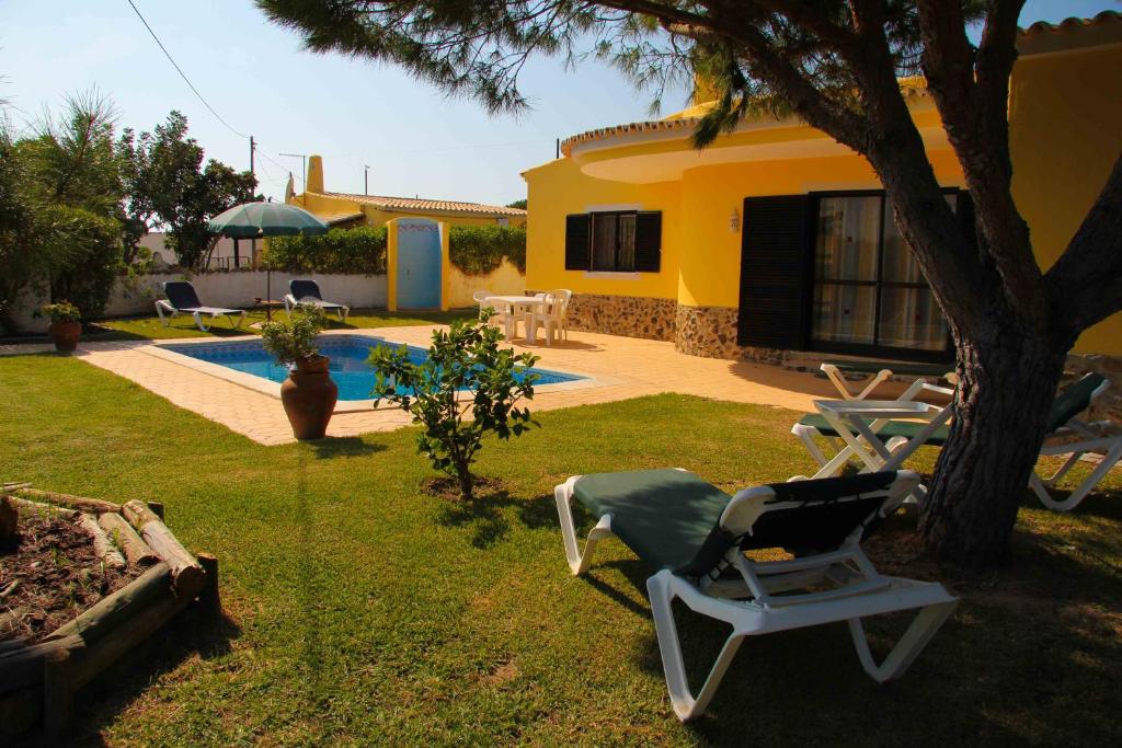 une cour avec une chaise et une maison dans l'établissement Quinta Vita - Vila Pera, à Almancil