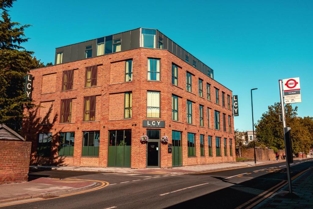 un edificio in mattoni rossi all'angolo di una strada di London City Airport Hotel a Londra