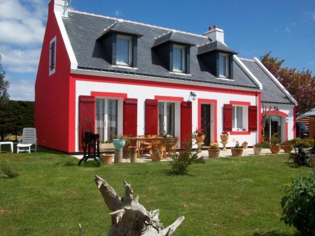 una casa roja y blanca con una mesa en el patio en Chez Jocelyne Lhermite, en Bangor