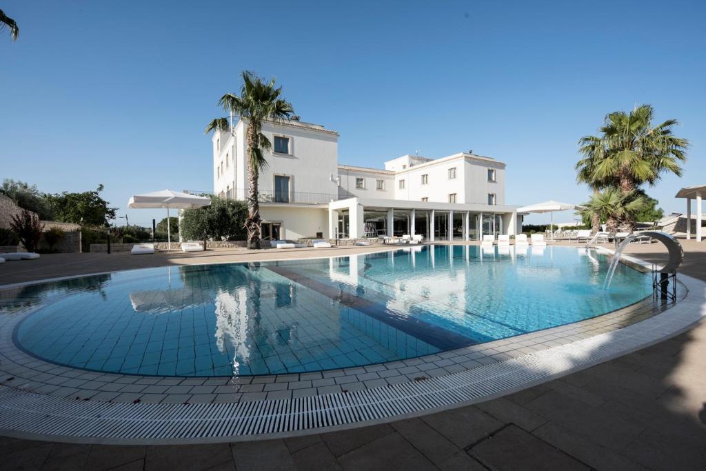 a large swimming pool in front of a building at Pietre Nere Resort & Spa in Modica