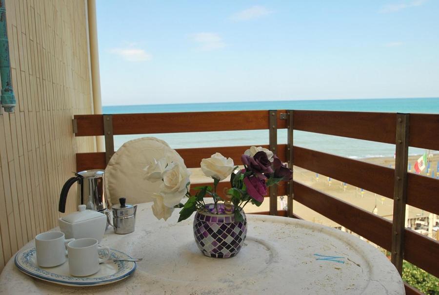 a table with a vase of flowers on a balcony at Appartamento- Murex in Marina di Castagneto Carducci