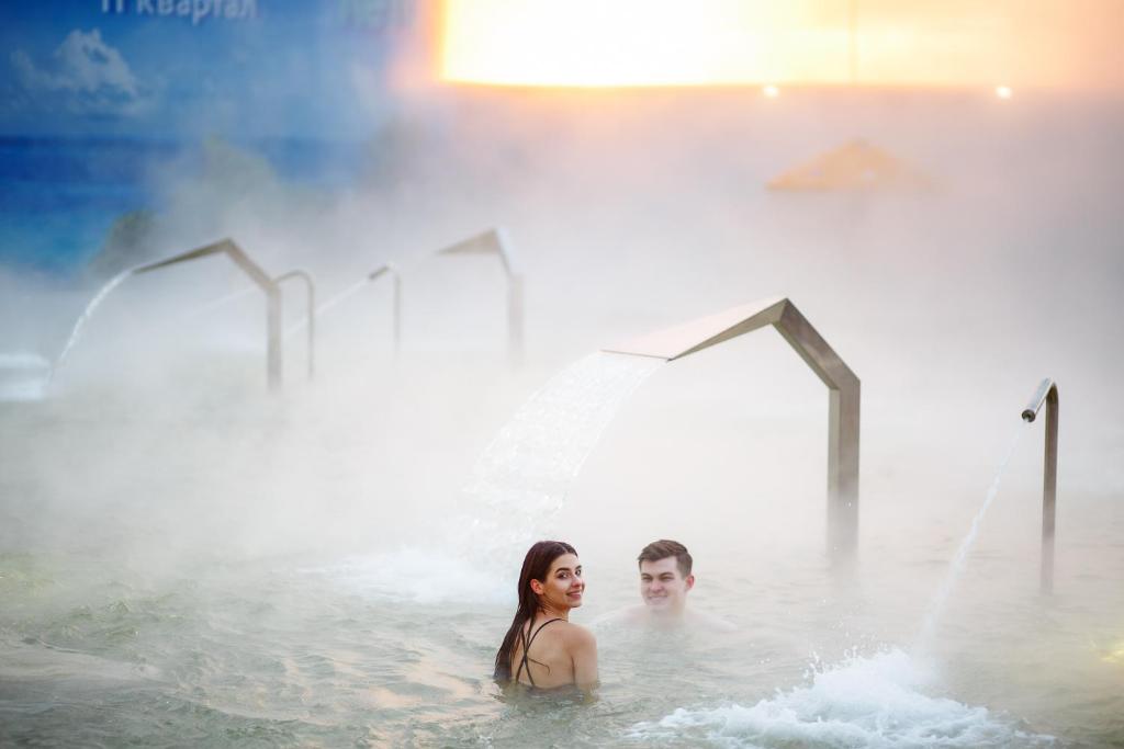 a man and a woman in the water in a hot tub at Марциаль in Tyumen