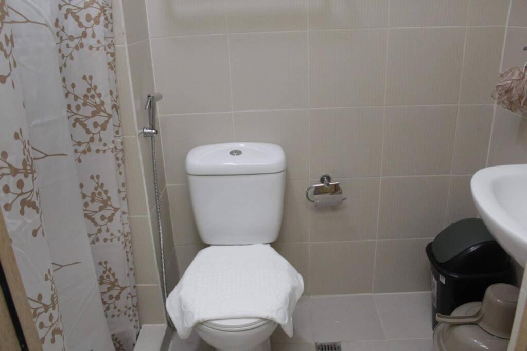 La salle de bains est pourvue de toilettes blanches et d'un lavabo. dans l'établissement SMDC Grass Residences - Unit # 2816, à Manille