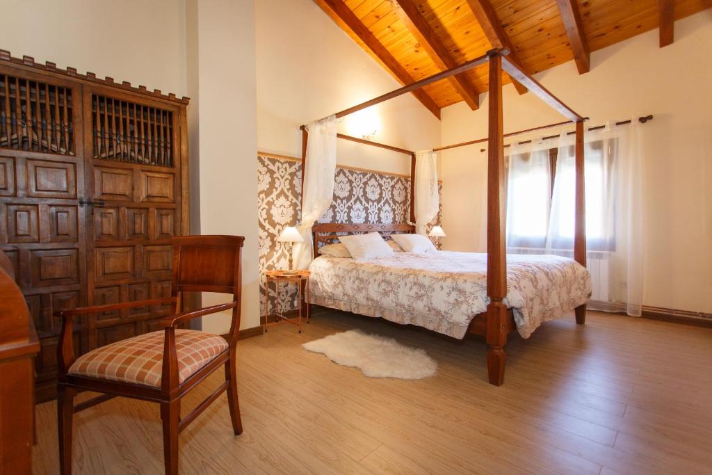 una camera con letto a baldacchino e sedia di El Bulín de Braojos - Casa Marta a Braojos de la Sierra