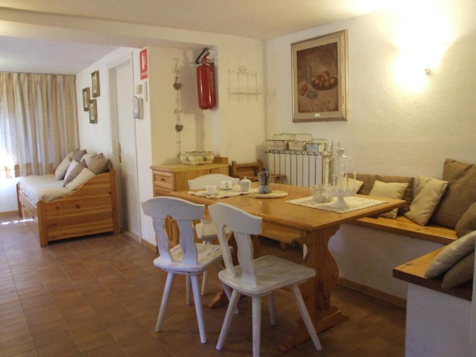 a living room with a wooden table and chairs at Camelia 2+2 in Marina di Castagneto Carducci