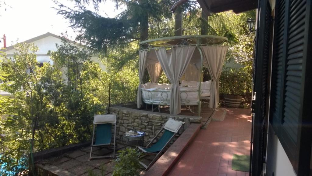 einen Garten mit einem Pavillon und Stühlen auf einer Terrasse in der Unterkunft La Quercia-Erica in Sassetta