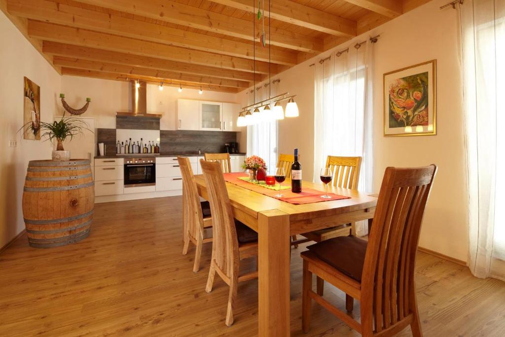eine Küche und ein Esszimmer mit einem Holztisch und Stühlen in der Unterkunft Weingut Schunck in Leinsweiler