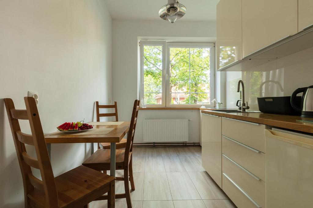 kuchnia z drewnianym stołem, stołem i krzesłami w obiekcie Gdynia Orłowo Apartament w mieście Gdynia