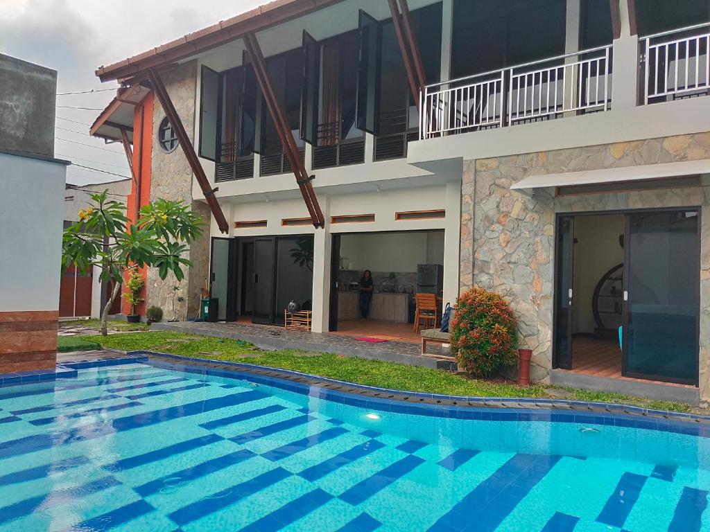 a swimming pool in front of a house at Jogja City Residence in Yogyakarta