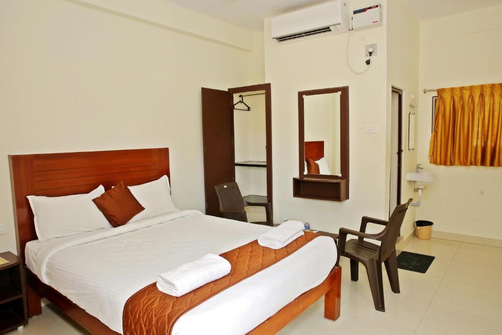 Rani Residency في بونديتْشيري: غرفة نوم بسرير وكرسي ومرآة