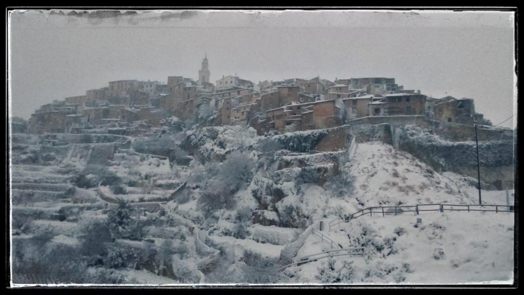 Casa Rural Casa Gimeno في بوكايرينت: مدينة مغطاة بالثلج فوق جبل