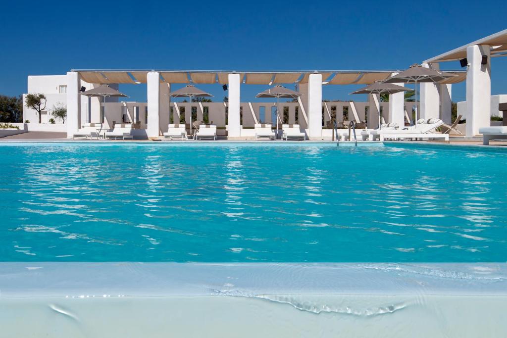 a swimming pool with a large swimming pool behind it at Archipelagos Resort in Agia Irini Paros