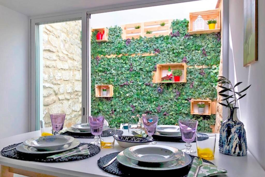 烏貝達的住宿－La Casita del Duente - Úbeda，一张桌子,上面有盘子和玻璃杯,还有绿色的墙