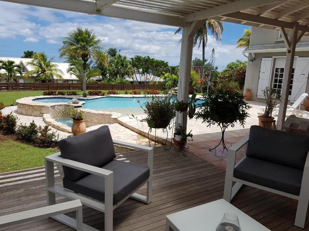 a patio with two chairs and a swimming pool at Villa Louise in Sainte-Rose