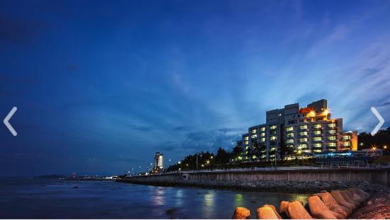 a large building next to the water at night at Benikea Hotel Mountain & Ocean Sokcho in Sokcho