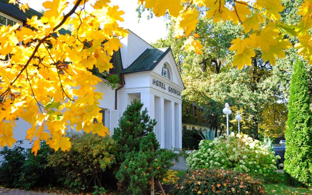 une maison blanche avec des feuilles jaunes sur elle dans l'établissement Hotel Ostrov, à Nymburk