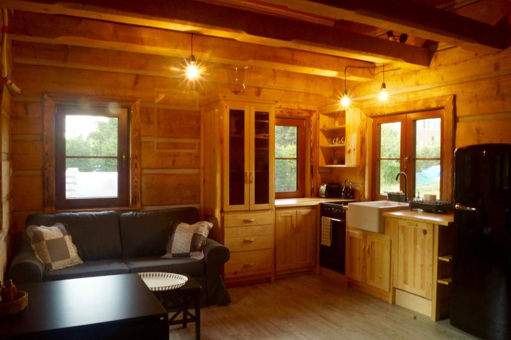 a living room with a couch and a kitchen at Smolnikowe Klimaty - Chyżula in Komańcza