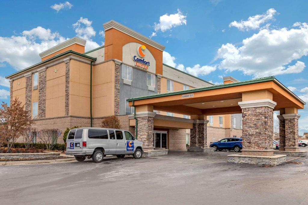 Comfort Suites Southgate-Detroit في ساوثغيت: مبنى به سيارة دفع رباعي متوقفة أمامه