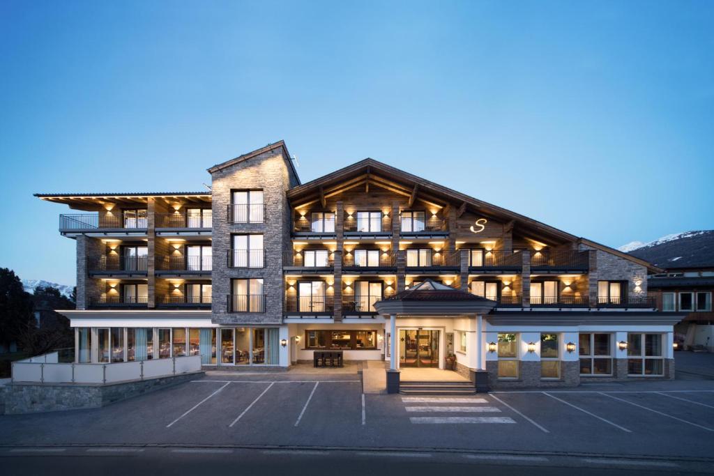 a large building with a parking lot in front of it at Hotel Stubai in Schönberg im Stubaital