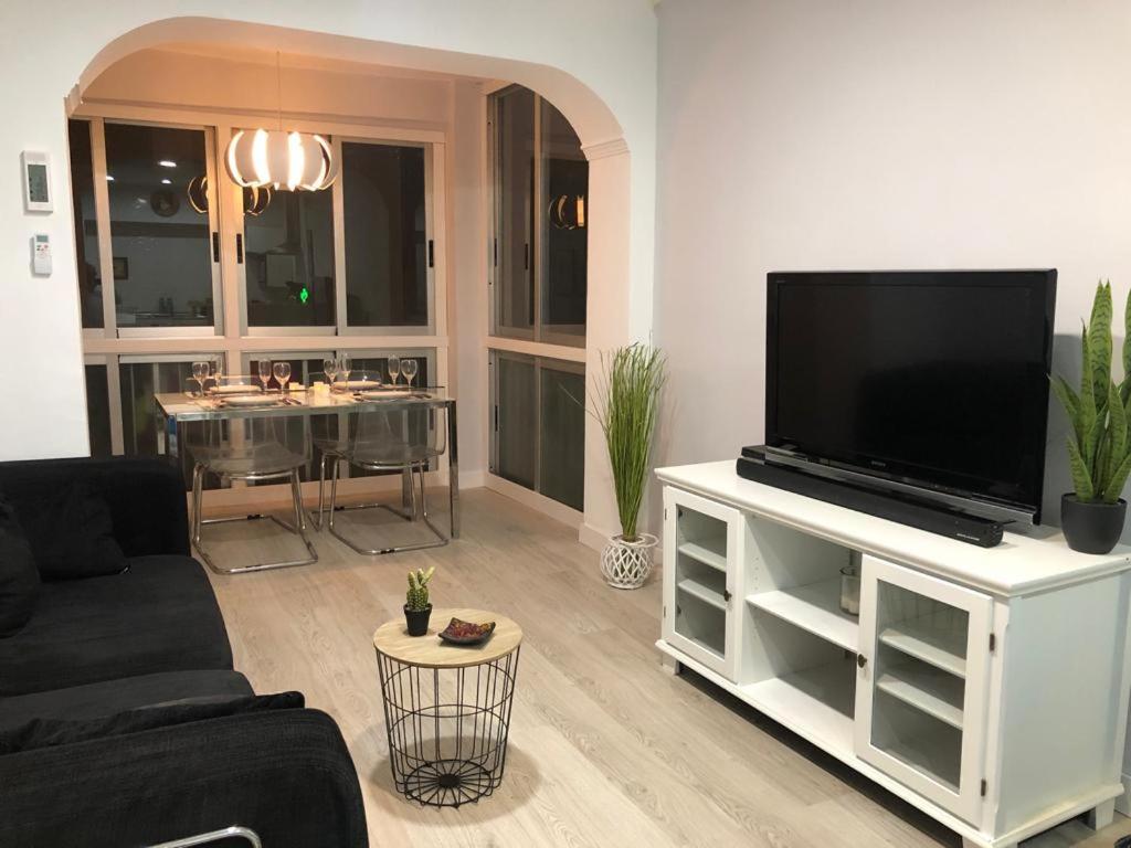Apartamento en Av Gabriel Miró - Calpe في كاليبي: غرفة معيشة فيها تلفزيون على مركز ترفيه ابيض