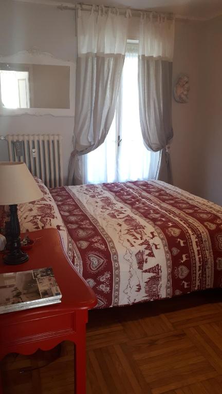 een slaapkamer met een bed met een rode tafel en een raam bij Appartamento Limone Piemonte in Limone Piemonte
