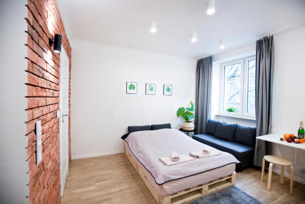 una camera da letto con un letto e un divano blu di Studio Gaba 2 INTRACO Apartment a Varsavia
