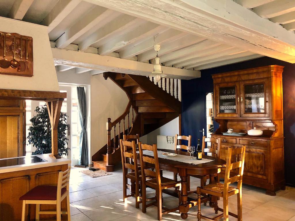 a dining room with a wooden table and chairs at Gîte La Maison d'Amélie in La Chapelle-Saint-Aubert