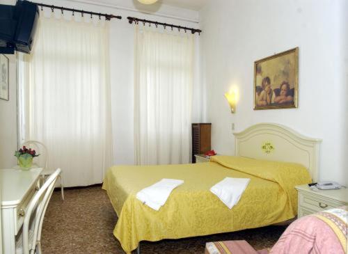 a bedroom with a yellow bed in a room at Hotel Airone in Venice