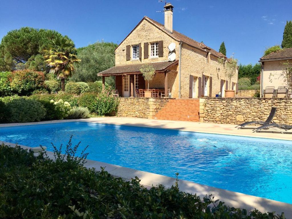 a house with a swimming pool in front of a house at Le domaine Aubazen in La Chapelle-Aubareil