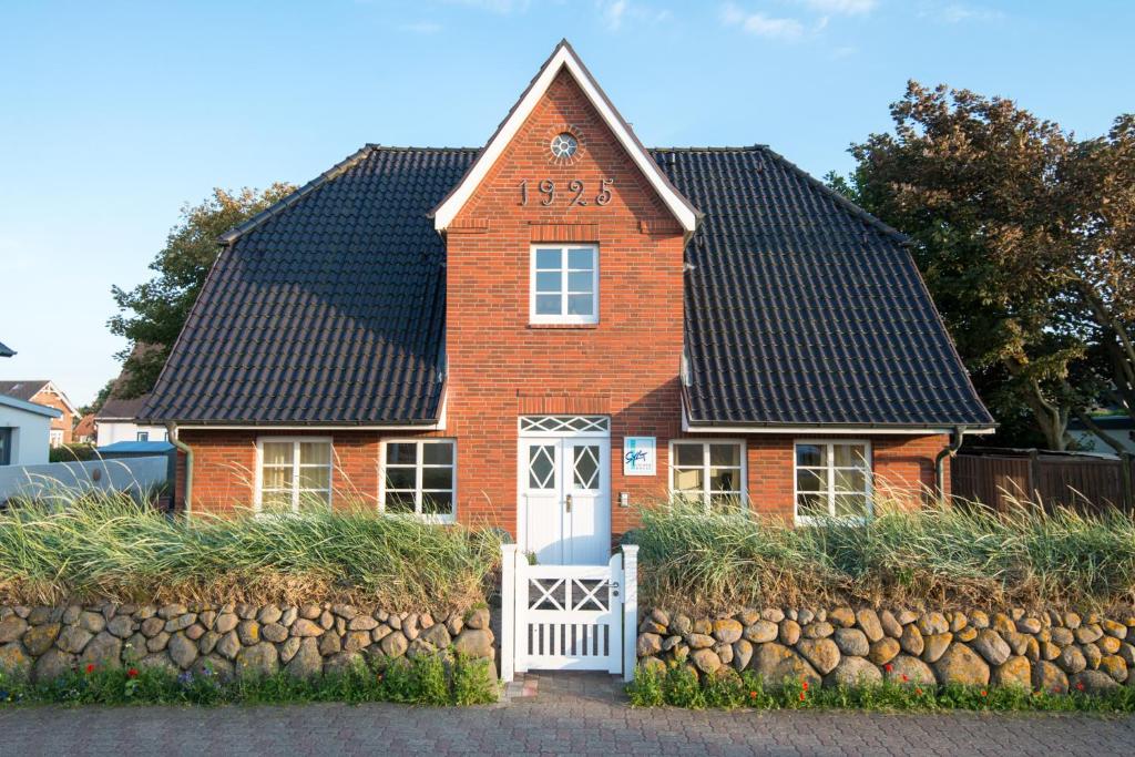 Sylt Island House في فيسترلاند: منزل من الطوب الأحمر على سقف أسود