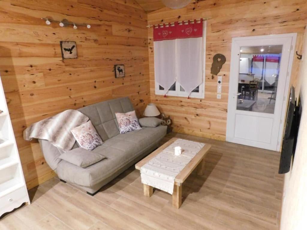 ein Wohnzimmer mit einem Sofa und einem Couchtisch in der Unterkunft logement paisible à la campagne (2 à 4 personnes) in Aubarède