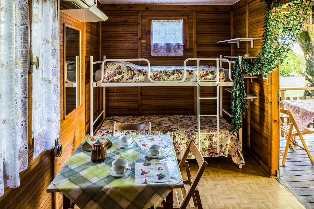 カヴァッリーノ・トレポルティにあるAppartamenti & Bungalows Luca Angiolinの二段ベッドとテーブルが備わる客室です。