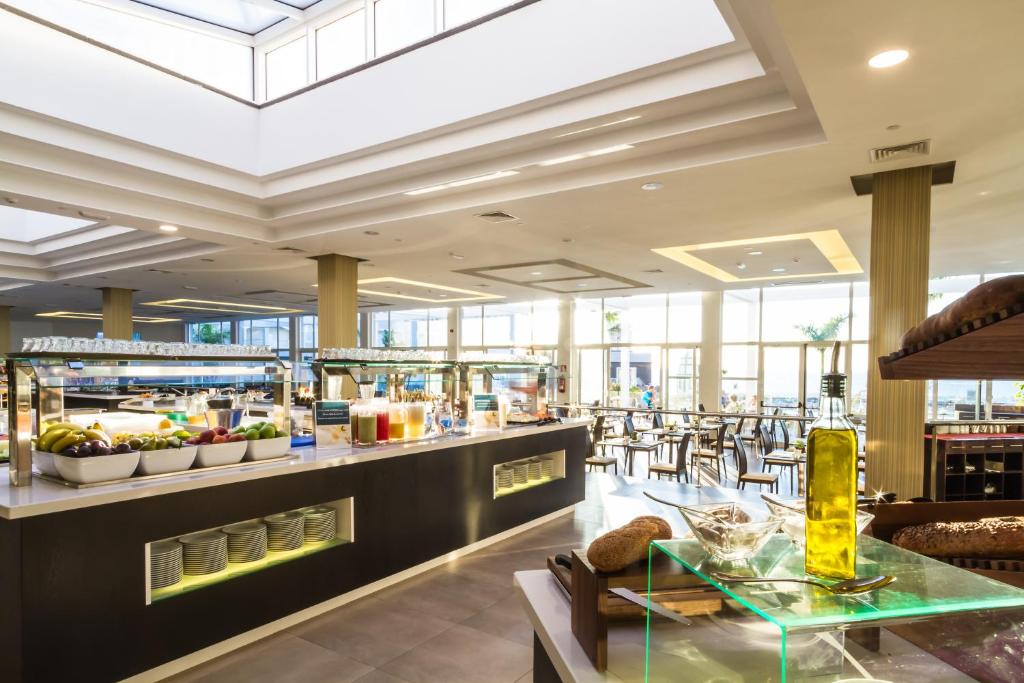 a restaurant with a buffet line with tables and chairs at Royal Palm Resort & Spa - Adults Only in Playa Jandia