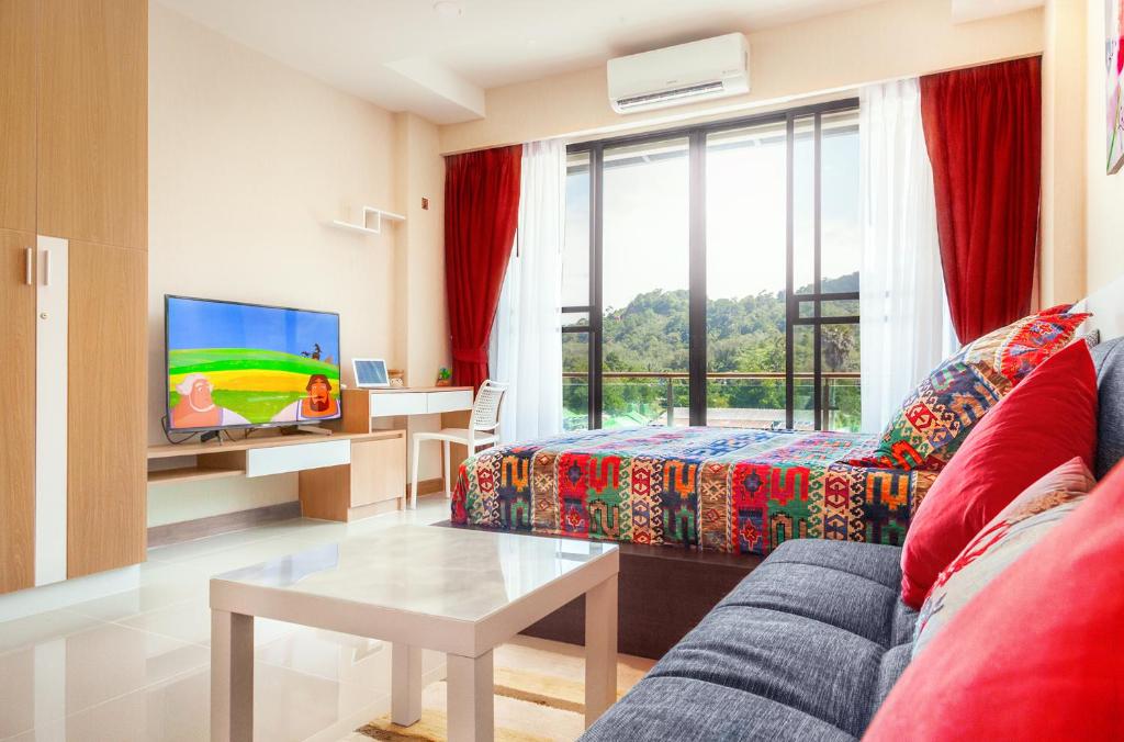 ein Wohnzimmer mit einem Sofa und einem TV in der Unterkunft The Nai Thon Condominium Unit in Nai Thon Beach